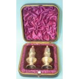 A pair of Victorian silver peppers, maker JB, London 1889, in silk-lined case.