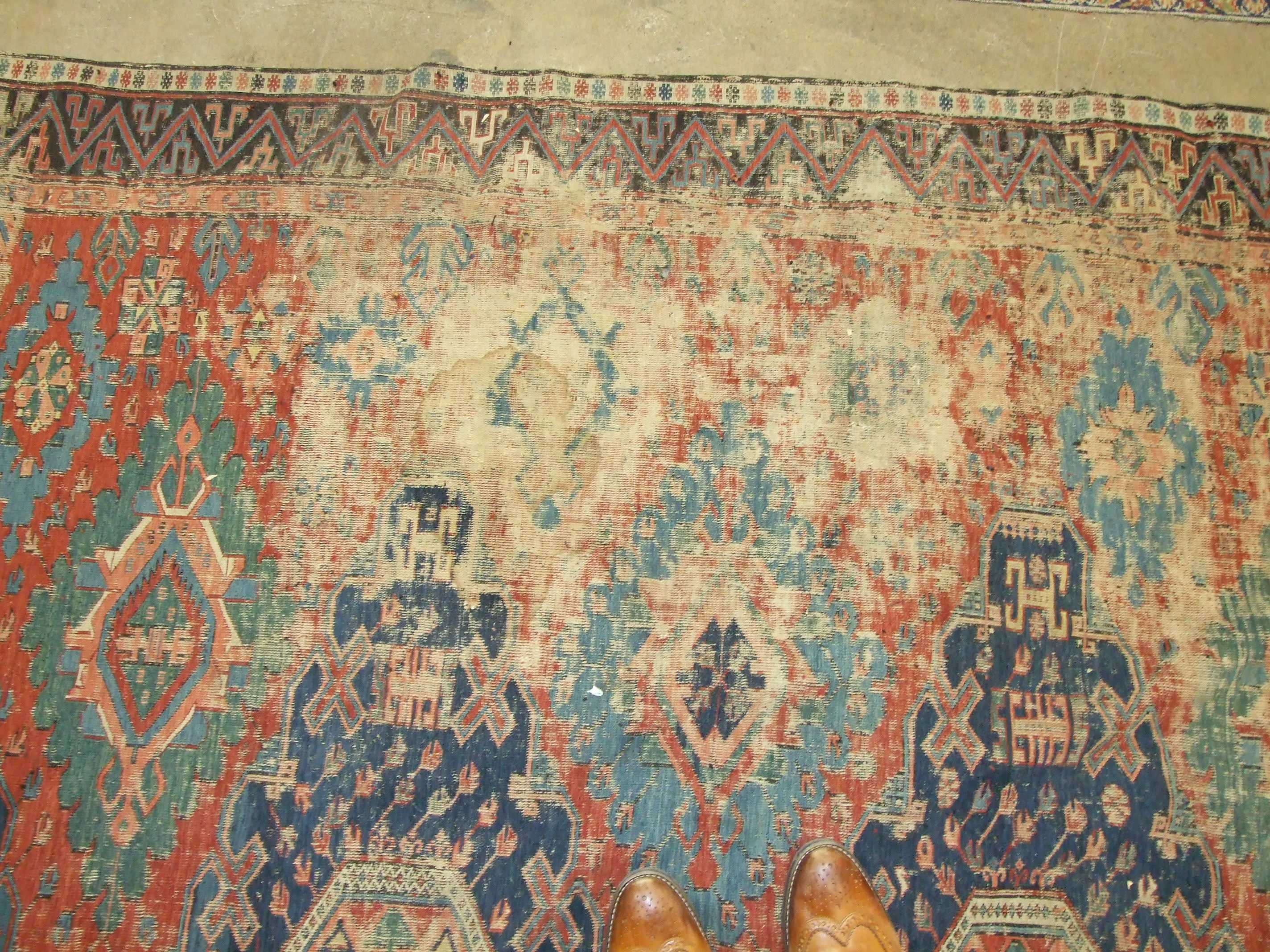 An antique Oriental carpet having four central blue ground lozenges and overall hooked medallions, - Image 5 of 5