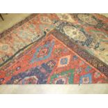An antique Oriental carpet having four central blue ground lozenges and overall hooked medallions,