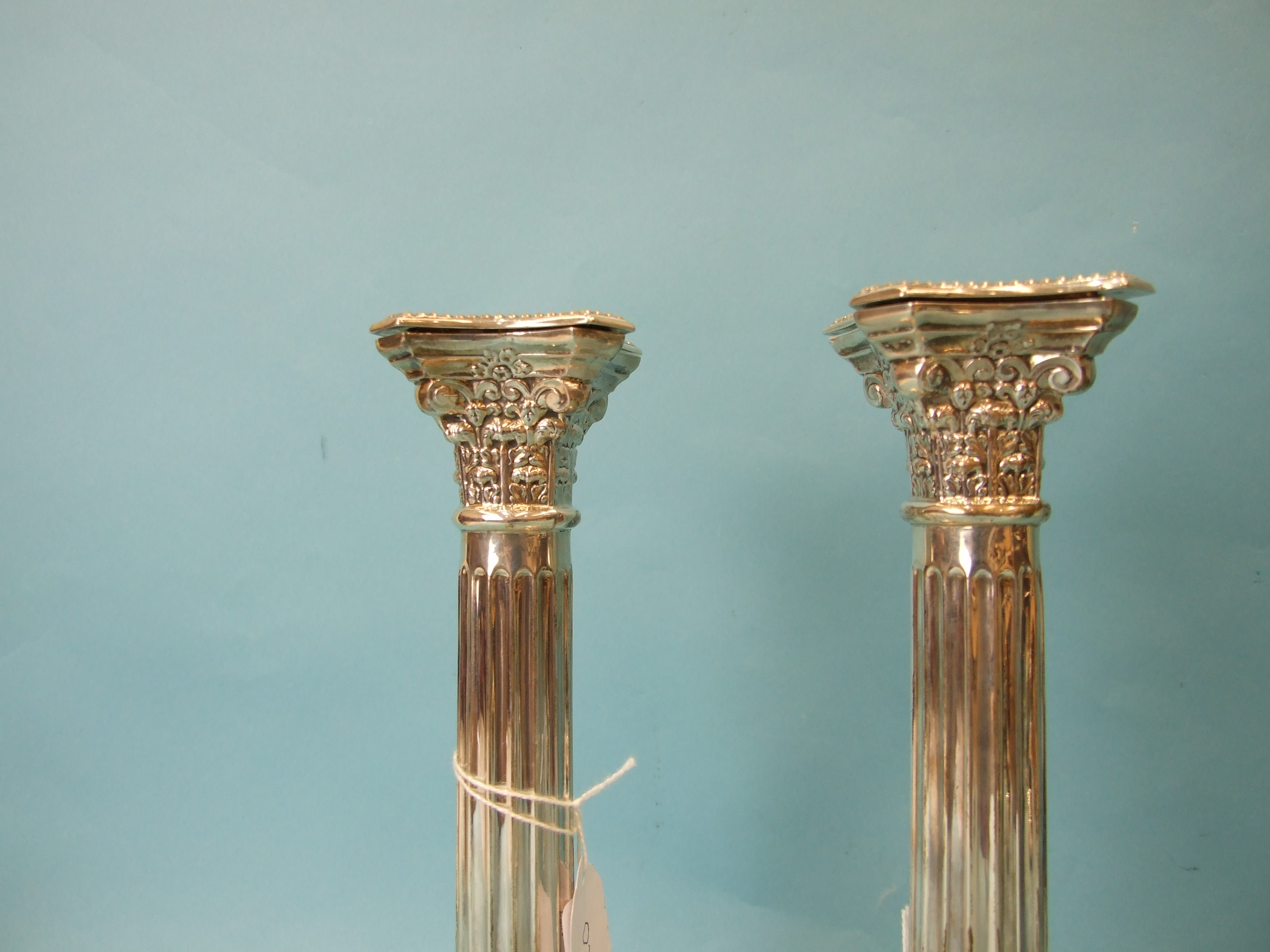 A pair of loaded silver Corinthian column candlesticks on stepped and beaded square bases, with drip - Image 2 of 5