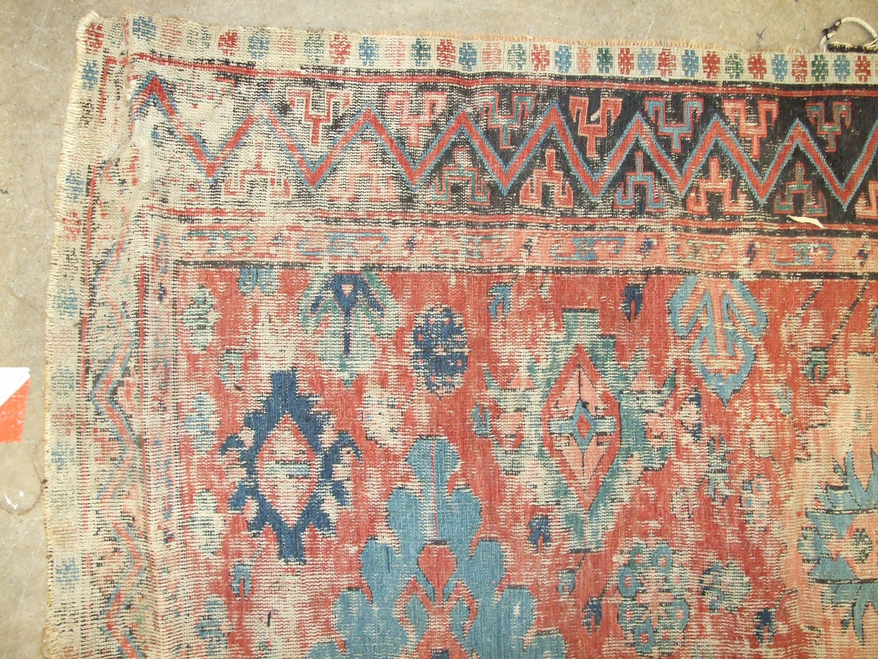 An antique Oriental carpet having four central blue ground lozenges and overall hooked medallions, - Image 4 of 5