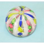 A St Louis glass paperweight decorated with alternating lattice and coloured ribbon strands, cane