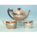 A silver three-piece bachelor tea service of oval form with half-reeded decoration, makers