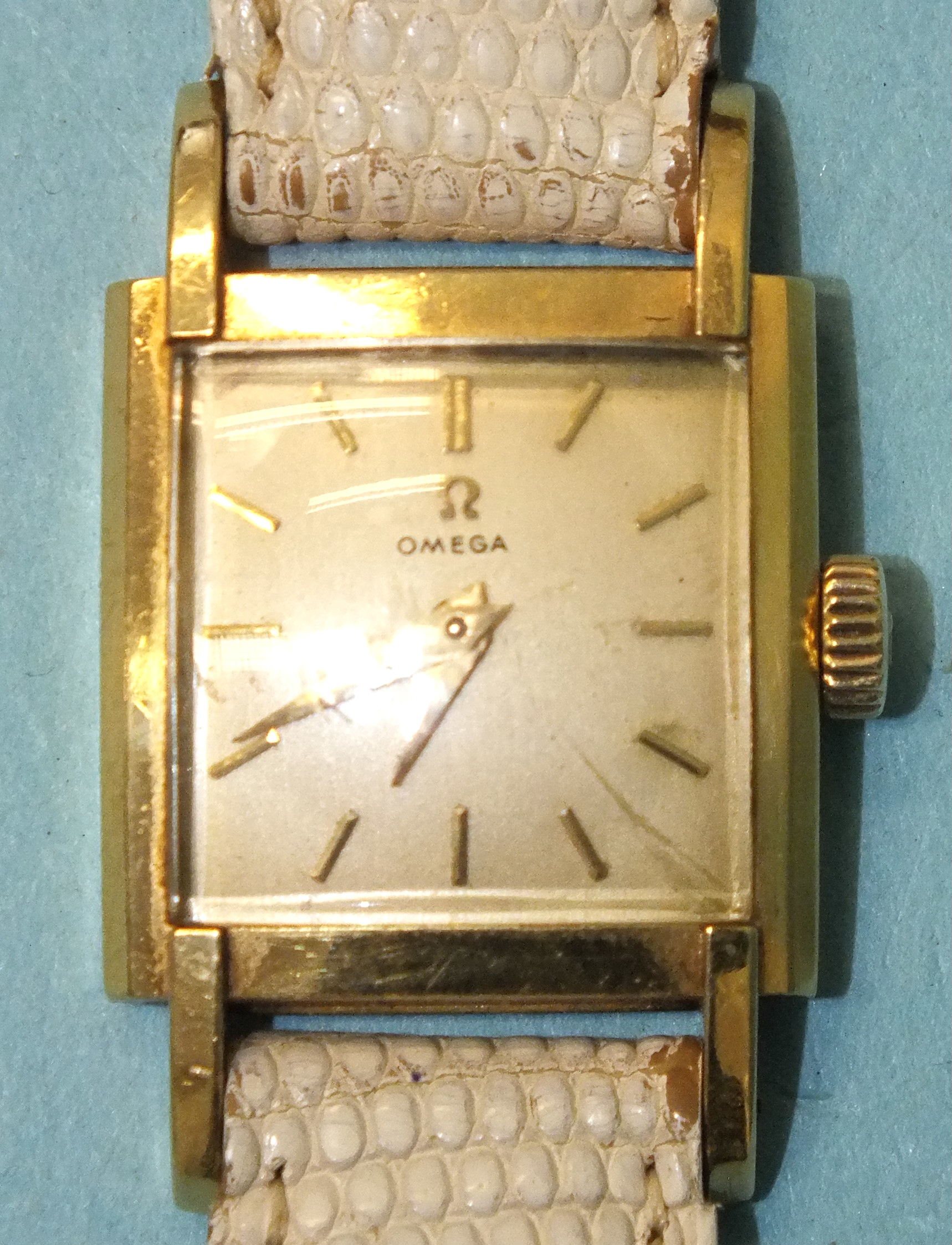 Omega, a lady's late-1950's 18ct gold-cased wrist watch, the square silvered dial with baton