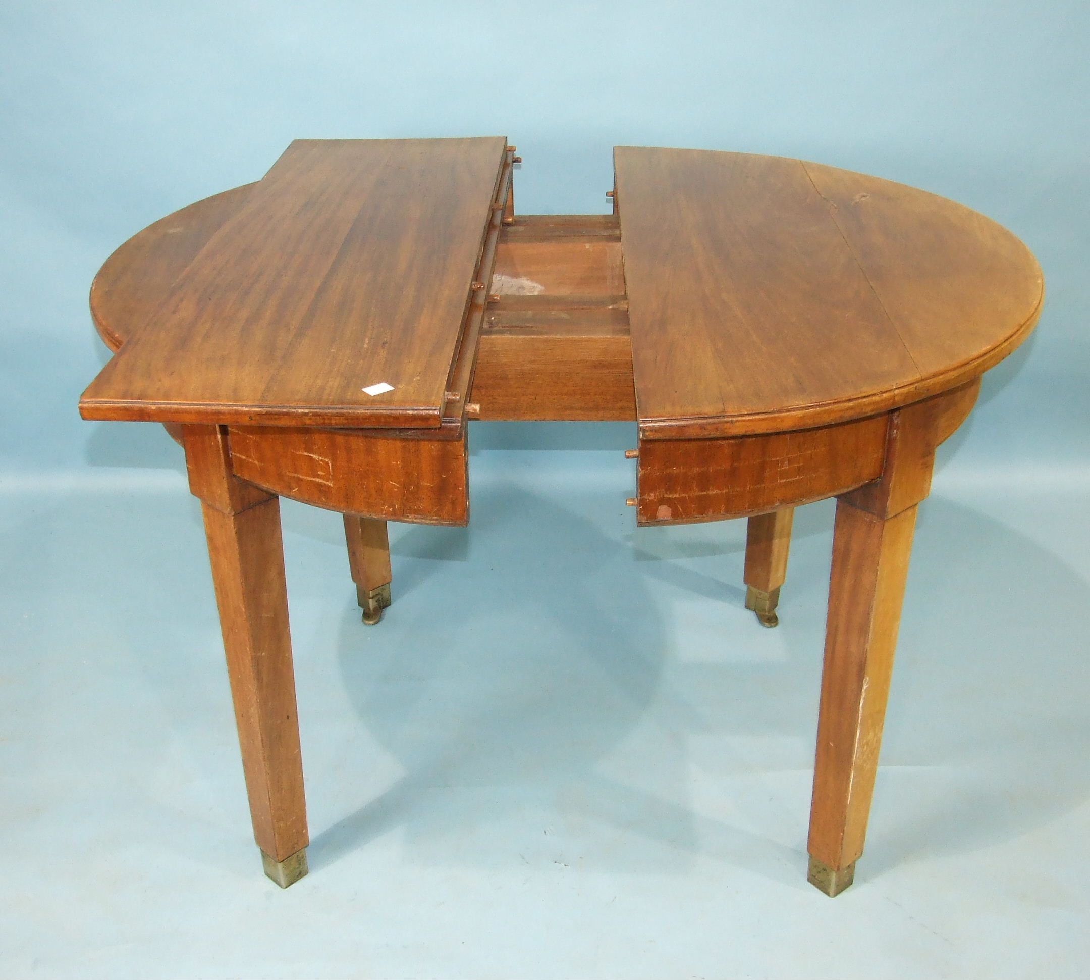 An early-20th century military mahogany extending 'D'-end dining table on plain square tapered