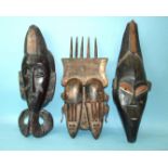 An African carved wood double-face mask with hatched decoration and surmounted by a 'comb', 51 x