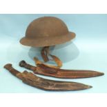 A British tin helmet, WWI, with leather liner by Hawkes & Co, 1 Savile Row, London and two kukri