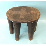 An African six-legged carved wood stool, 24cm high, 27cm diameter.