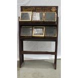 A grocer's metal shelf unit with six glass-topped display biscuit tins: Huntley & Palmers (x3),