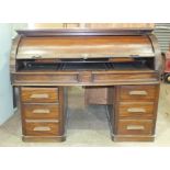 A 19th century hardwood cylinder estate desk, enclosing an arrangement of drawers, pigeon holes