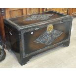 A 20th century Chinese camphor wood blanket chest, the hinged lid and front panel with carved
