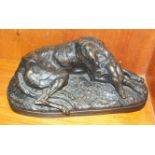 After Paul Joseph Raymond Gayrard, a bronzed sculpture of a reclining deerhound signed Gayrard,