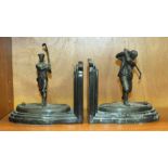 A pair of bronzed golfing bookends, each with a golfing figure on a naturalistic oval base and