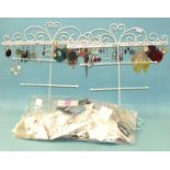 A large quantity of earrings (for pierced ears) on retailers' cards and two wire display racks for