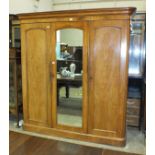A late-Victorian mahogany sectional wardrobe, the cornice above three doors opening to reveal four