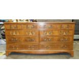 A modern yew wood low chest fitted with an arrangement of nine drawers, 153cm wide, 74cm high.