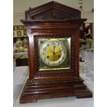 A stained wood case striking mantel clock, the movement stamped Junghans, 44cm high, (a/f).