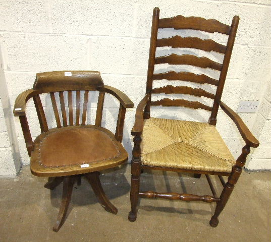 An oak revolving office armchair with padded seat and a set of six stained wood ladder-back dining