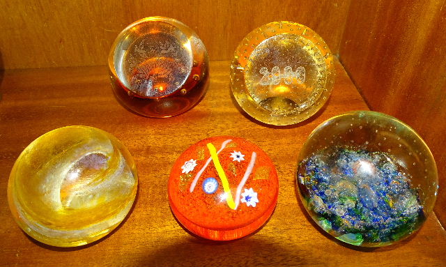 A Selkirk glass paperweight 'Starstream' and four Caithness glass paperweights: 'Millennium