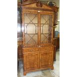 A burr elm glazed bookcase, having a pair of astragal-glazed doors, above two drawers and two