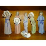 A collection of four Lladro figures of young women, another of a duck with ducklings in a basket and