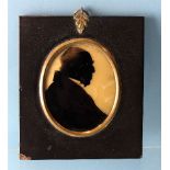 An early-19th century silhouette of a gentleman, painted on convex glass backed with wax, labelled