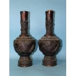 A pair of 19th century Japanese bronze vases with birds and floral embossed decoration, 36cm high.