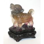 A Chinese hardstone carving of a standing kylin, on a carved wood base, 10cm.