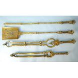 A set of three heavy fire brasses, the handles with crown and masks decoration, twist columns,