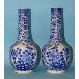 A pair of 19th century Chinese porcelain bottle vases decorated with panels of birds in branches, on