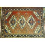A modern Oriental rug with central pole medallion and foliate spandrels on a brick red ground, 210 x