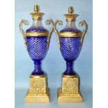 A pair of contemporary gilt-metal-mounted blue overlay glass table lamps of two-handled urn shape,