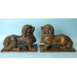 A pair of Oriental carved wood and gilt lacquered temple dogs, 24cm high, 33cm wide.