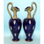 A pair of Royal Doulton stoneware ewers of baluster shape, the neck and handle with mottled green/