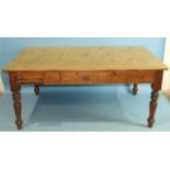 A pine farmhouse kitchen table, the seven-plank top above a drawer and pastry slide, on turned legs,