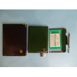 A Rolex black leather wallet with Rolex insignia to front and a green Rolex wallet with