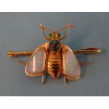 A 20th century yellow gold bee brooch with black opal-set thorax, water opal wings and carved gold