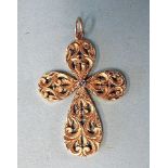 An 18ct yellow gold pendant of stylised cross form, with pierced and engraved decoration centred