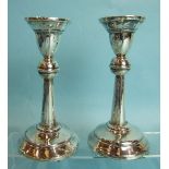 A pair of loaded candlesticks on circular bases, Birmingham 1915, 14.3cm high.