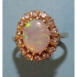 An opal and diamond cluster ring claw-set an oval opal within a border of fourteen 8/8-cut diamond