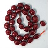 A string of dark cherry amber-style Bakelite beads, (needs re-stringing), 86g, 22 x 17 x 11mm to