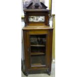 A walnut display/music cabinet, the mirrored back above a single glazed door.