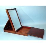 An early-19th century mahogany travelling mirror, the rectangular folding case revealing a moulded