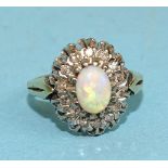 An opal and diamond cluster ring, claw-set an oval opal within a surround of fourteen 8/8-cut