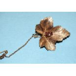 A 9ct rose gold leaf brooch set five small round-cut garnets, 30mm long, 6.7g.