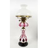 Victorian glass oil lamp in cranberry with white overlay and white glass shade
