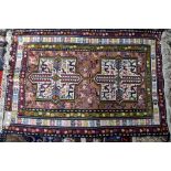 Kazak rug with two central medallions with bird motifs on a peach ground within stylised borders,