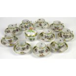 Herend cups and saucers and a sugar bowl with cover, decorated with butterflies and flowers, with