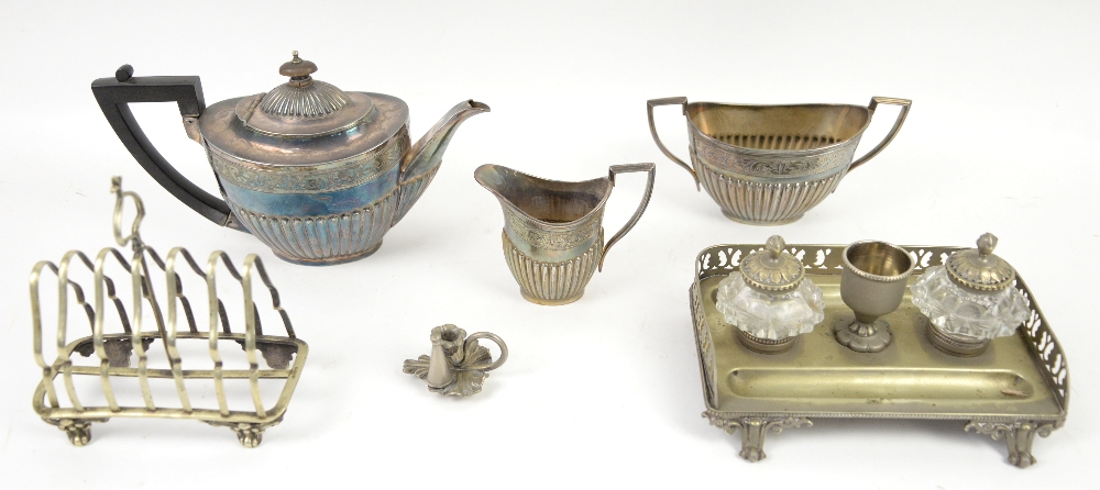 Small group of silver plate to include a three piece tea service, toast rack and desk set, bottle