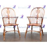Pair of oak and beech Windsor elbow chairs one chair has a heavily scratched seat, and faded